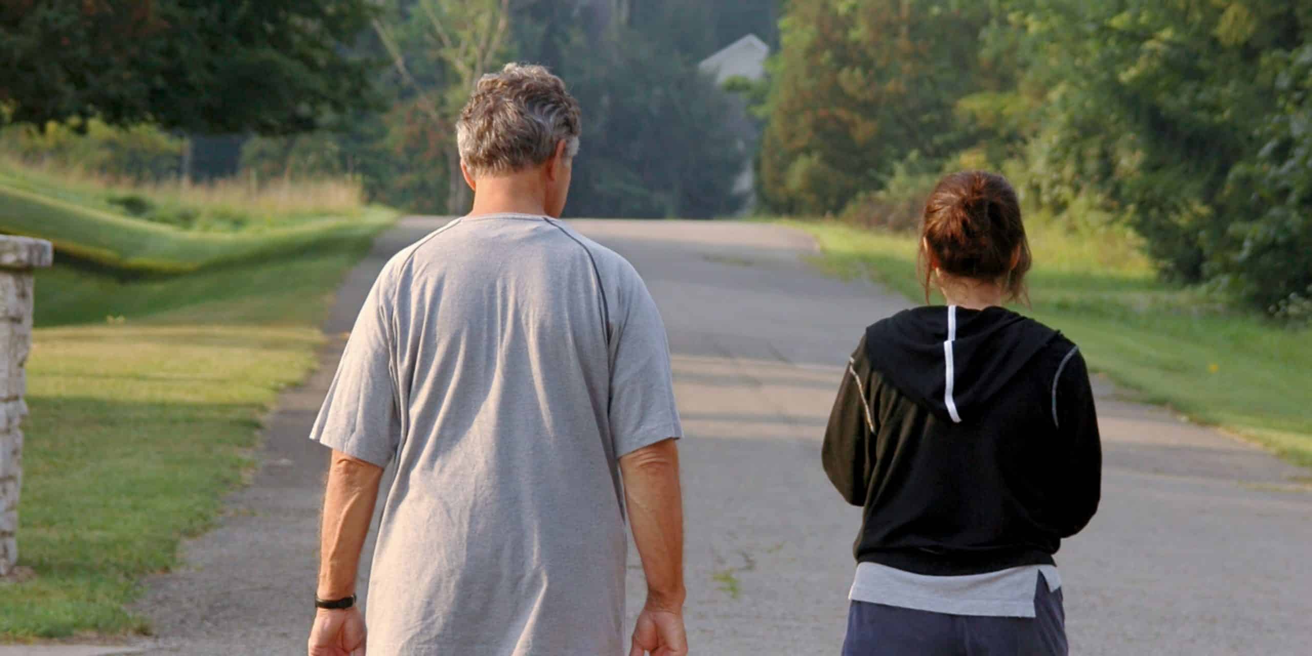Twee mensen wandelen naast elkaar in een groene omgeving