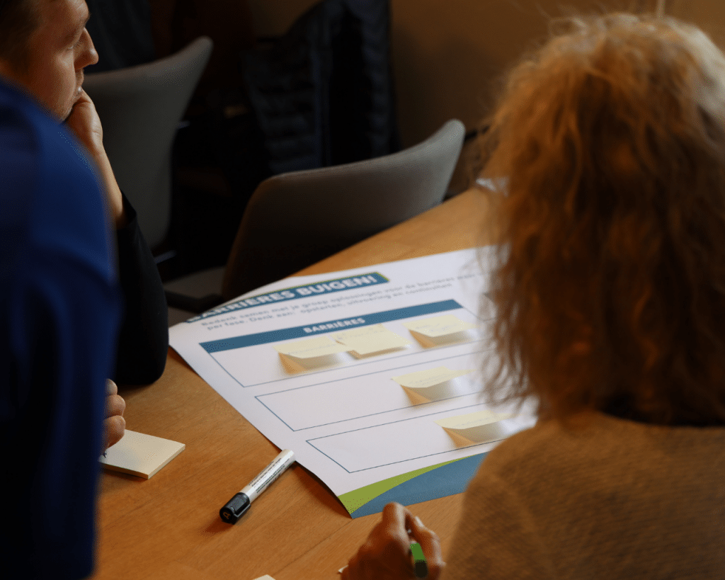 Dame die zich buigt over een groot invulblad tijdens de break-outsessie 