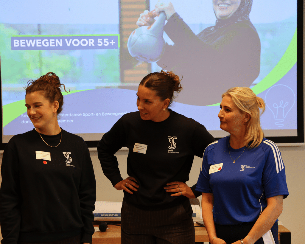 Drie Team Sportservice collega's presenteren trots en met lachende gezichten de breakout sessie