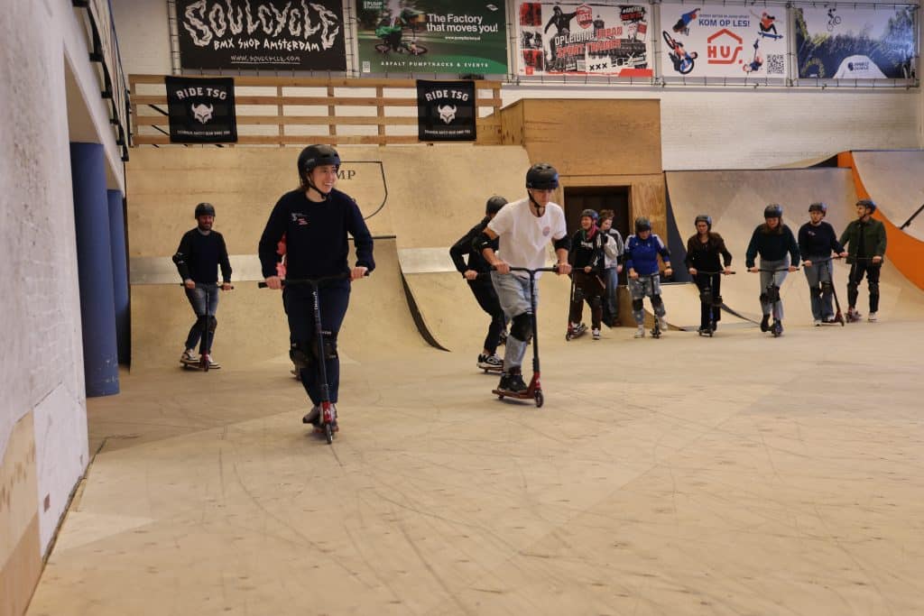 Deelnemers Urban Sportcafé steppen op de indoor skatebaan van House of Urban Sports